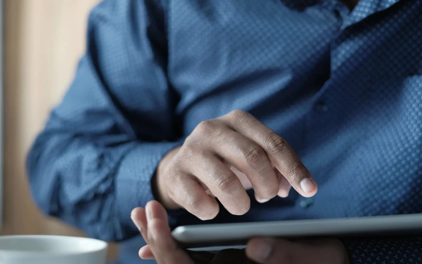 Hands using a tablet to review an operational dashboard